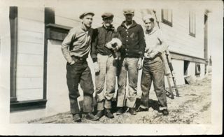 4 men standing outside a building