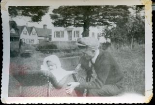 Man with baby in carriage, Mullen house in background.