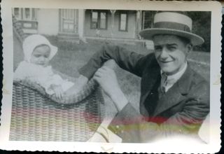 man with baby in wicker carriage