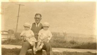 Loren Rumill holding his twin grandchildren