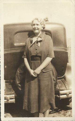 Esther Gott, standing near automobile