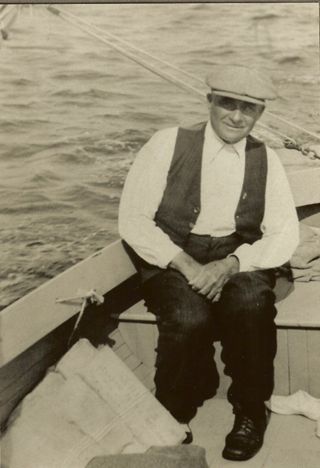 Sylvester Gott at the helm of a sailboat